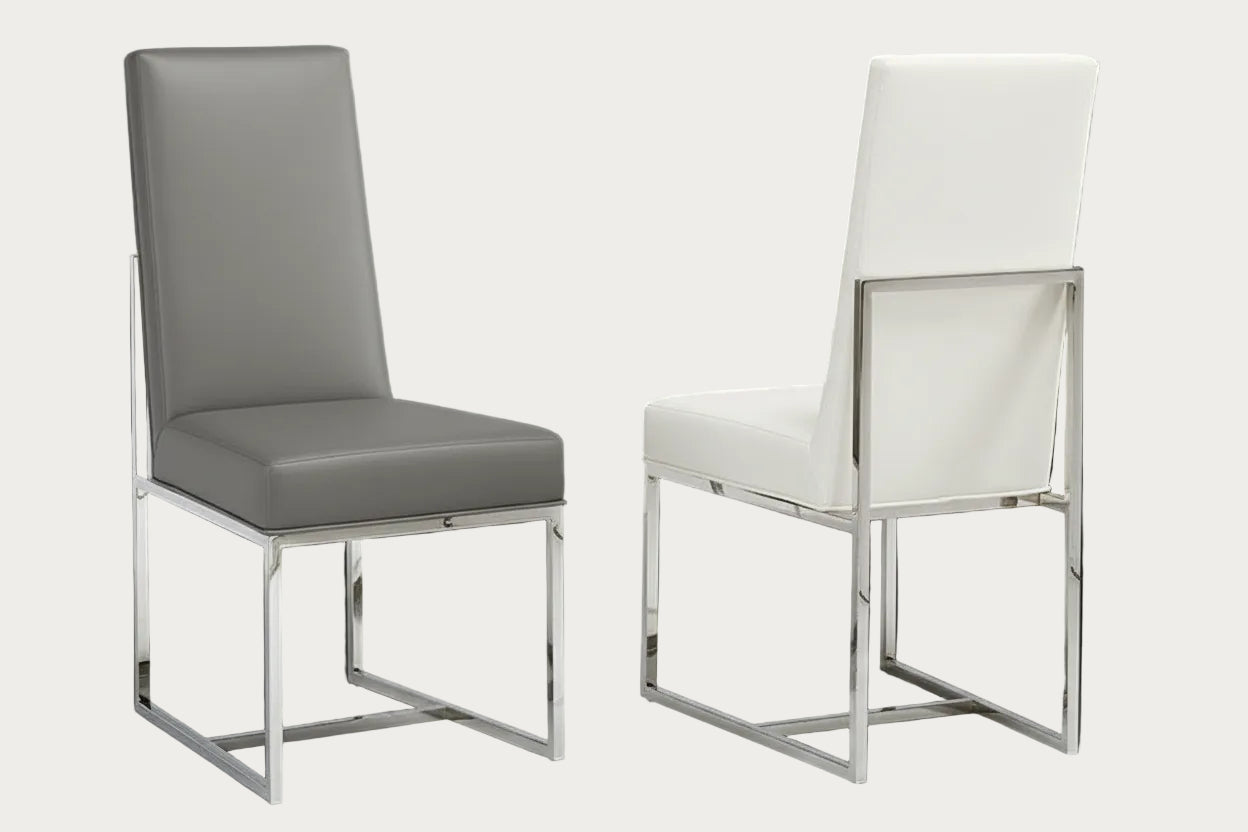 Two Bess chairs, one with a gray cushion and the other with a white cushion, on a dark background.
