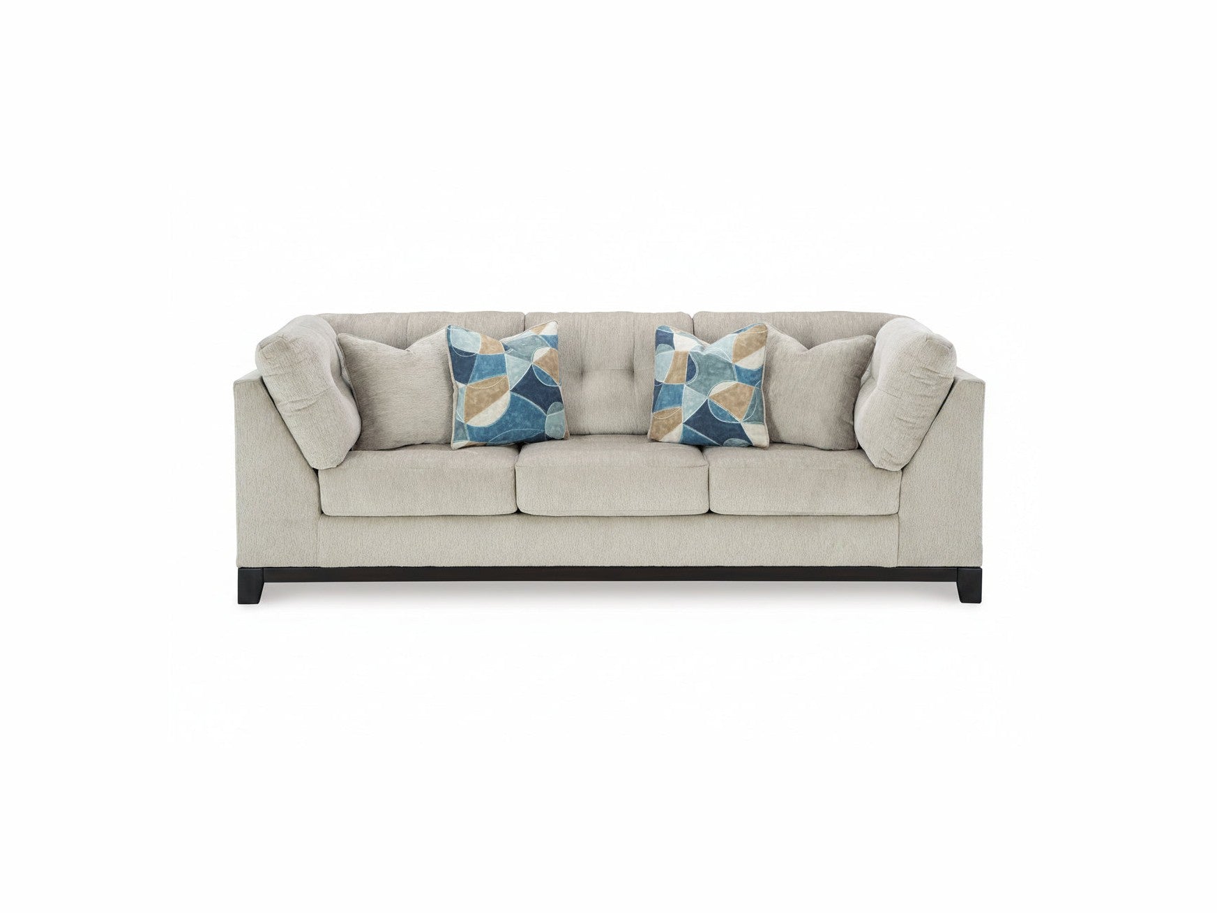 Beige sofa with two patterned blue and beige pillows on a white background
