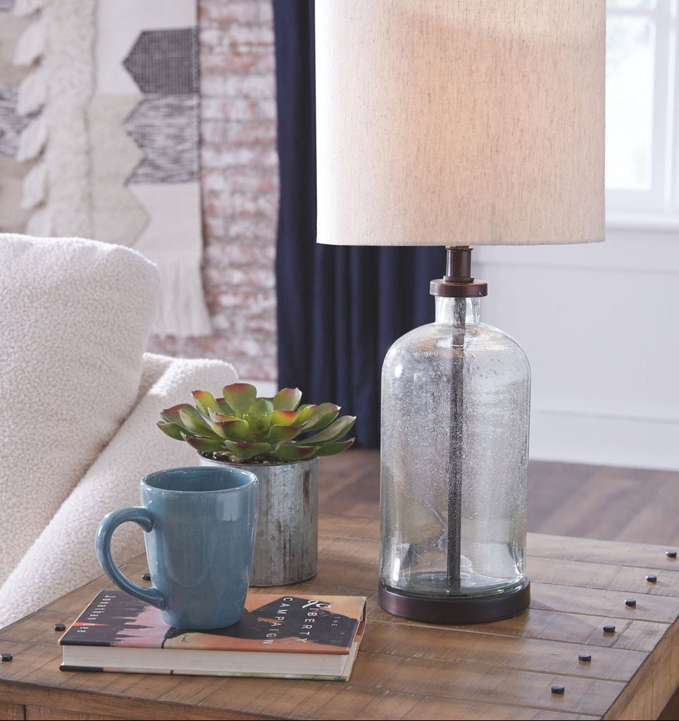 Decorative lamp on a table with a mug and book in a cozy living room setting.