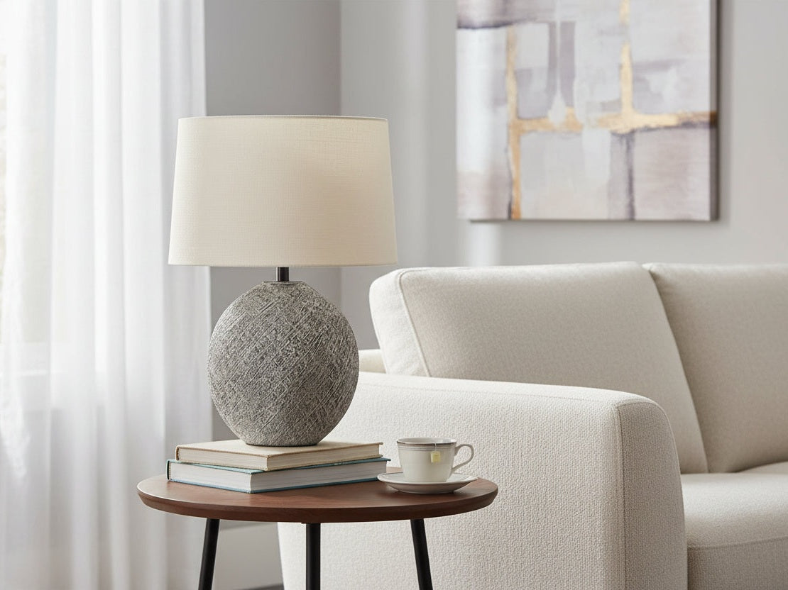 Harif table lamp with textured gray base and beige lampshade on a white background.