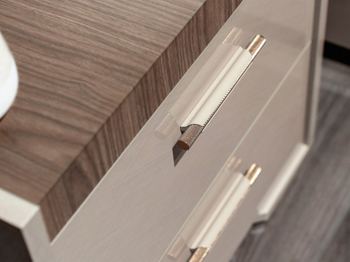 Close-up of a modern drawer with a light beige front, a medium brown woodgrain top, and sleek metallic handles.