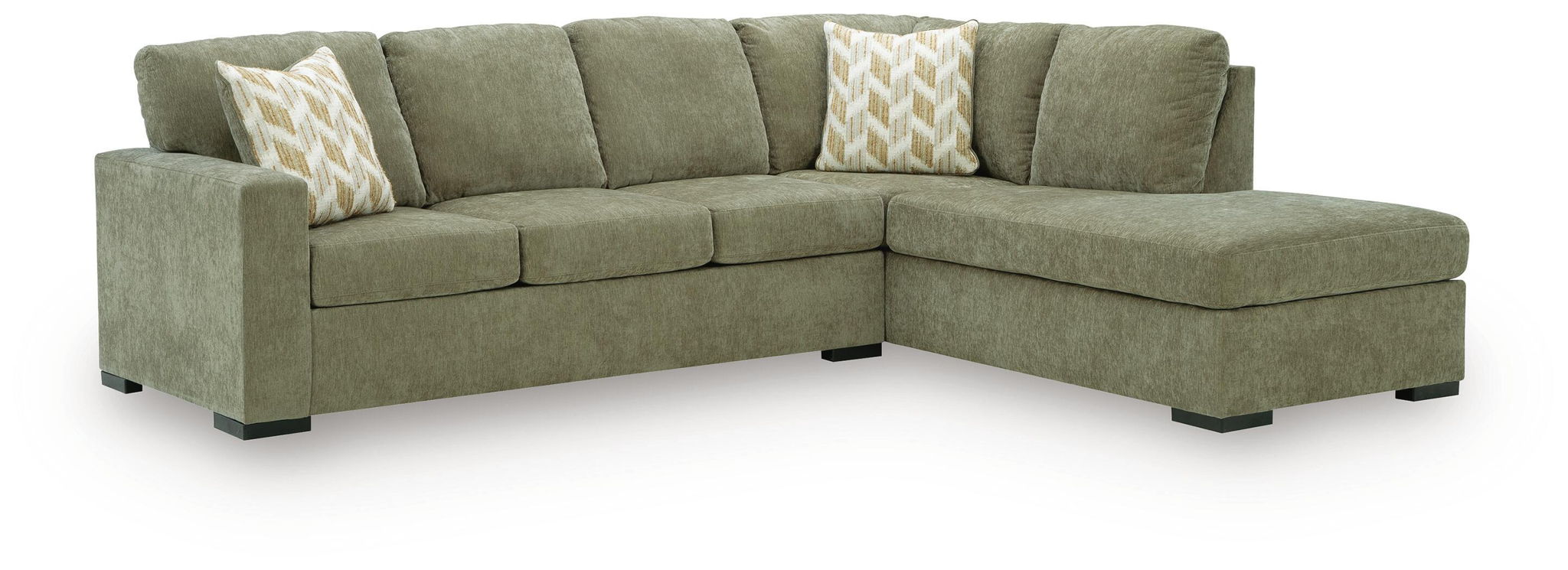 An L-shaped sectional sofa upholstered in textured sage green fabric, featuring two patterned throw pillows and black legs, shown on a white background.