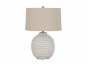 Jamon table lamp with textured base and beige lampshade on a white background.