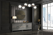 Modern interior design with a sideboard, lamp, and decorative items in a room with large windows.