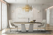 Modern marble dining table and chairs, gold chandelier, and large windows.