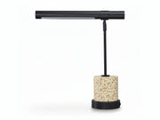 Table lamp with stone base and black adjustable arm on a white background