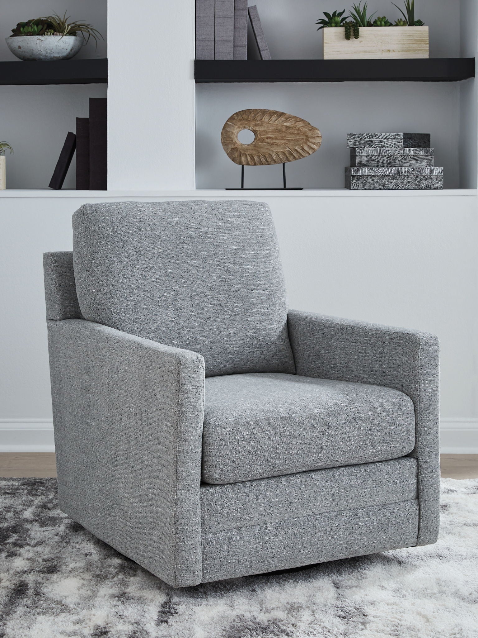 Gray armchair in a room with shelves and decor