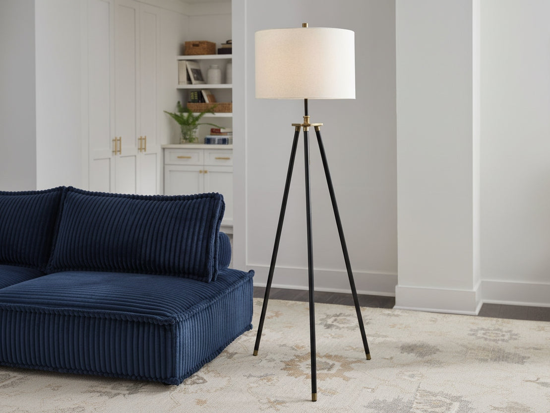 Tall floor lamp with a white shade in a living room setting.
