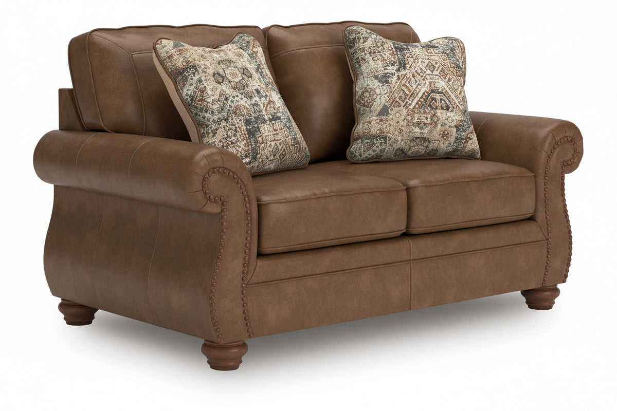 Brown leather sofa with patterned pillows on a white background