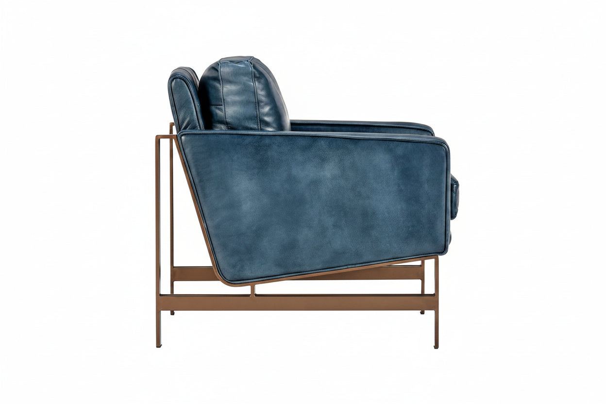 Blue leather armchair with bronze frame on a white background, side view.