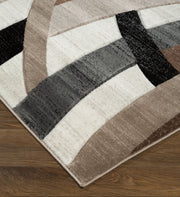 Geometric patterned rug with brown, black, and white colors on a wooden floor.