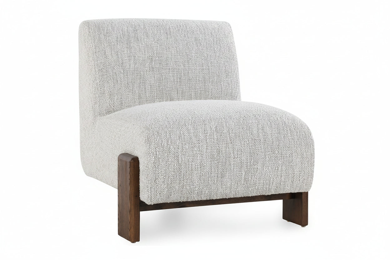 A modern low-profile accent chair with a textured light gray bouclé fabric upholstery and dark brown wooden legs, shown against a plain white background.
