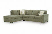 An L-shaped sectional sofa upholstered in textured sage green fabric, featuring two decorative throw pillows with a beige and white chevron pattern, set against a plain white background.