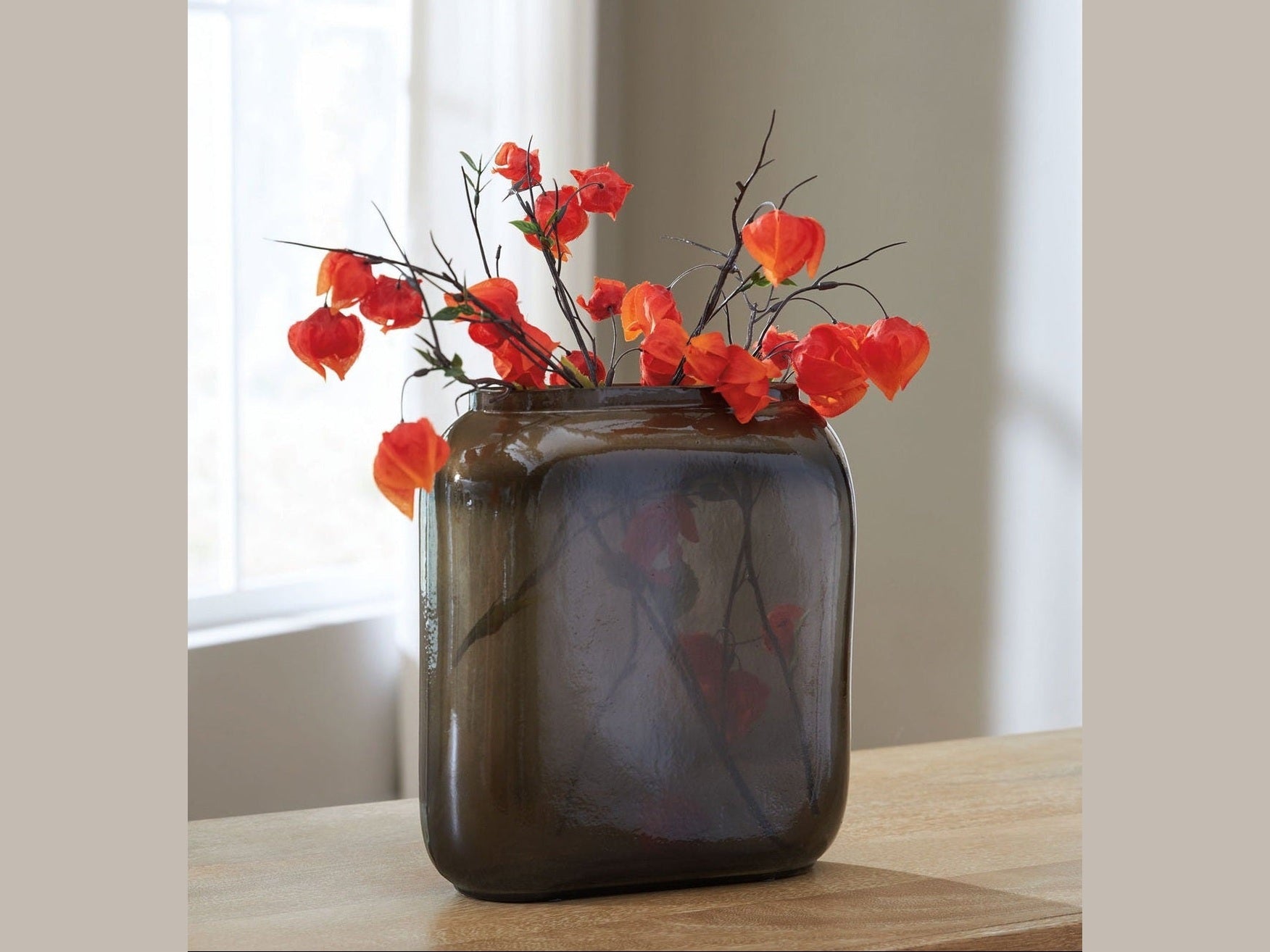 Sumner decorative vase with red flowers on a wooden surface.