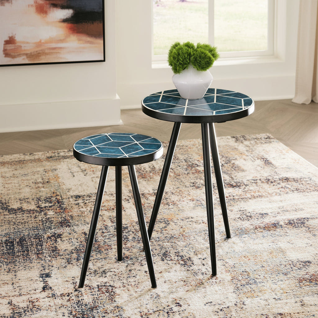 Two small round Clairebelle tables with blue mosaic tops and black legs on a patterned rug.
