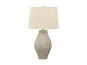 Table lamp with textured base and beige fabric shade on a white background