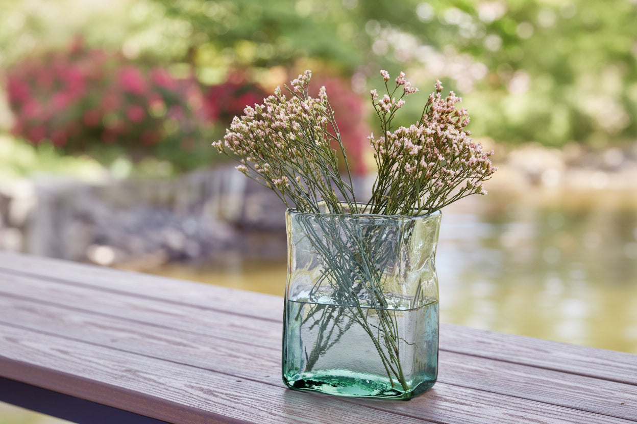 Taylow green glass vase with dried flowers on a wooden surface outdoors