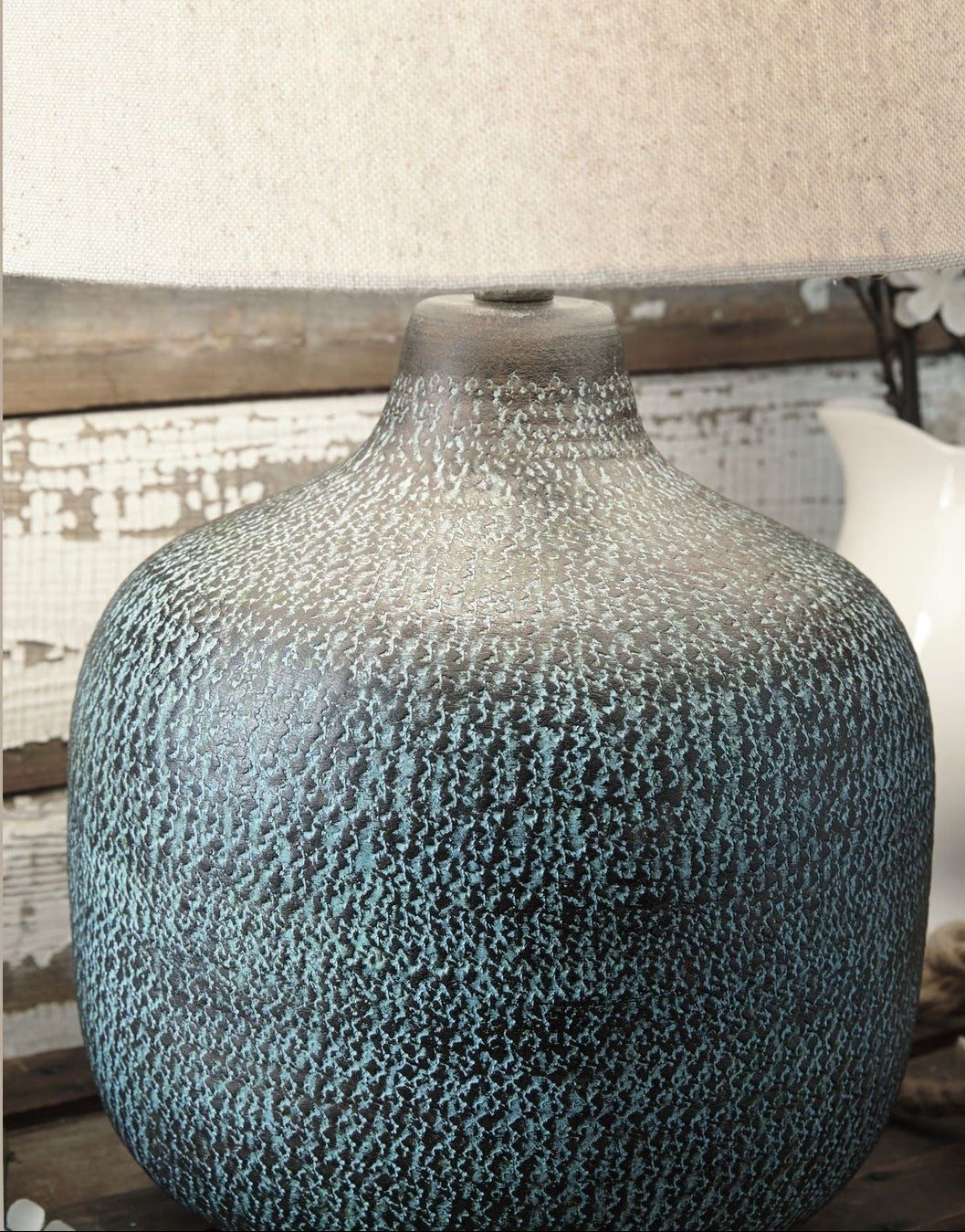 Textured blue vase on a wooden surface with a neutral background