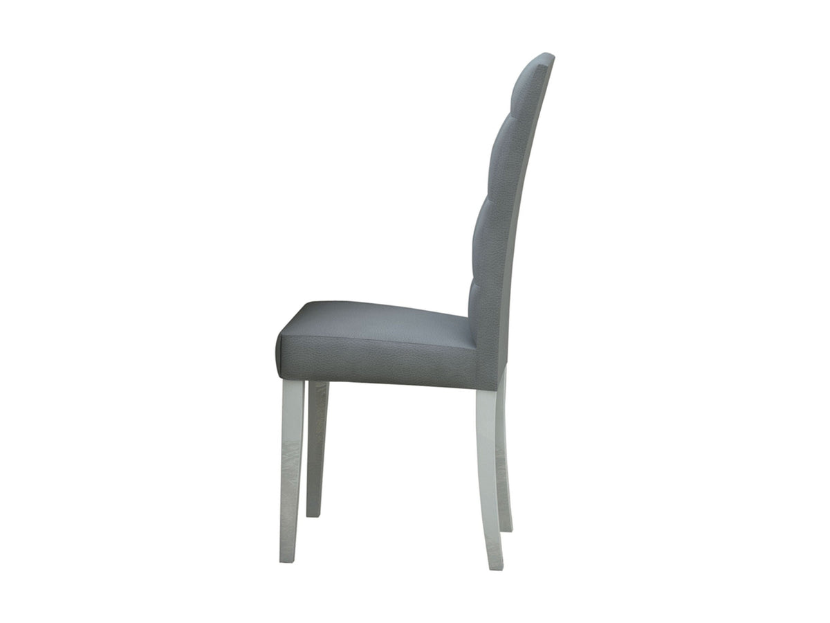 A gray upholstered dining chair with a tall scalloped backrest and light-colored wooden legs, shown from a side profile on a white background.