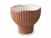Terracotta-colored ceramic bowl with ribbed texture on a white background