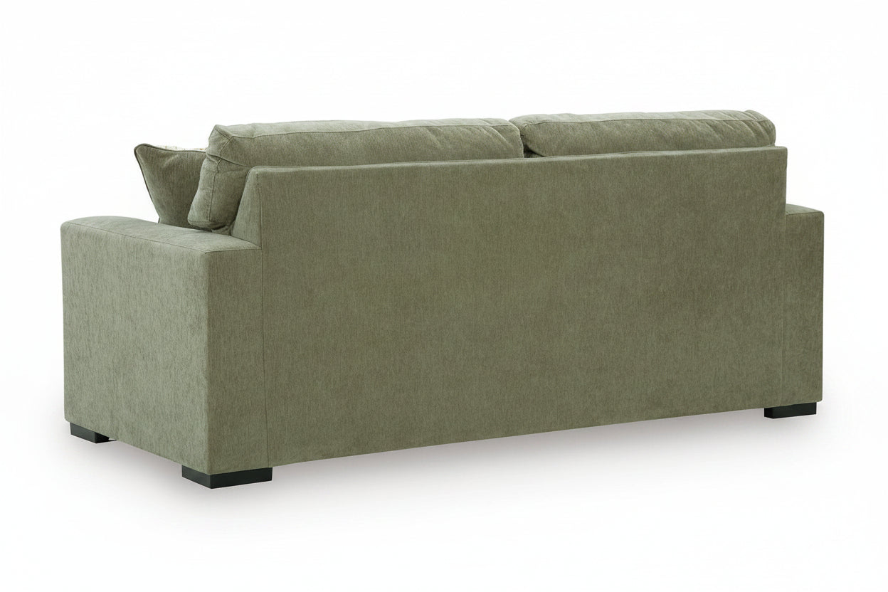 An upholstered loveseat sofa shown from the rear three-quarter angle, featuring a textured sage green fabric and dark feet, set against a plain white background.