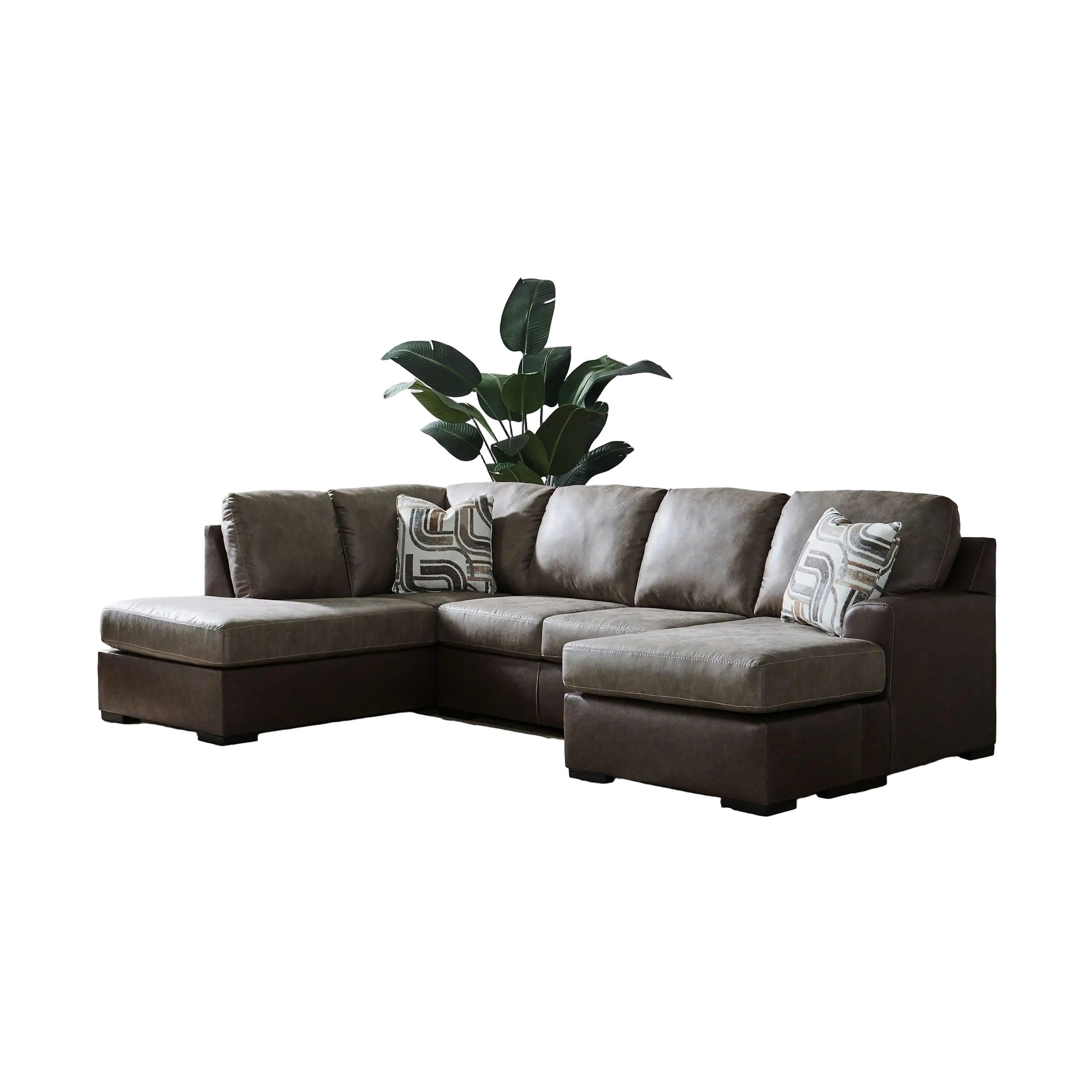 Brown sectional sofa in a living room with a plant and artwork on the wall.