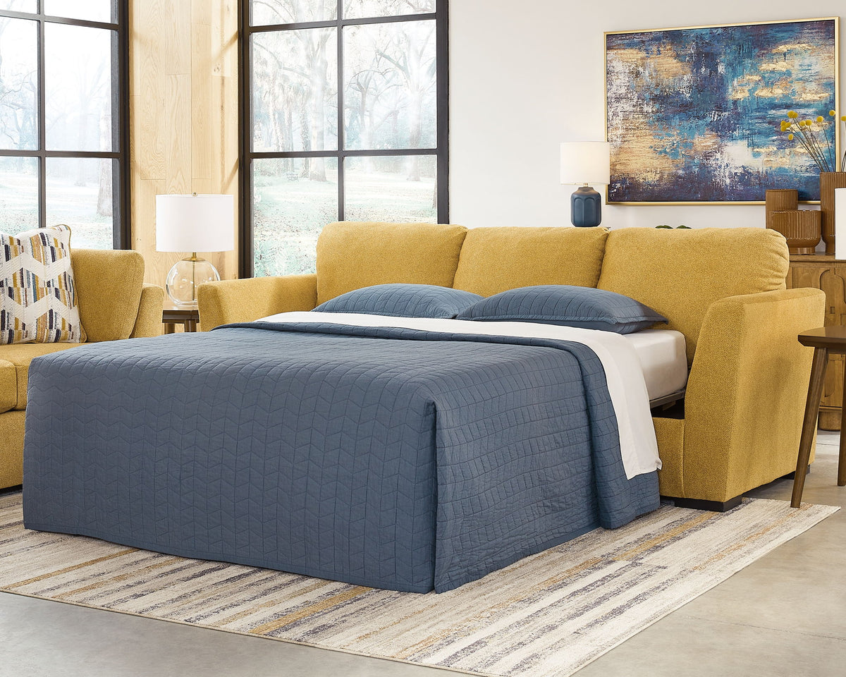 Yellow sectional sofa converted into a bed with blue bedding in a living room setting.