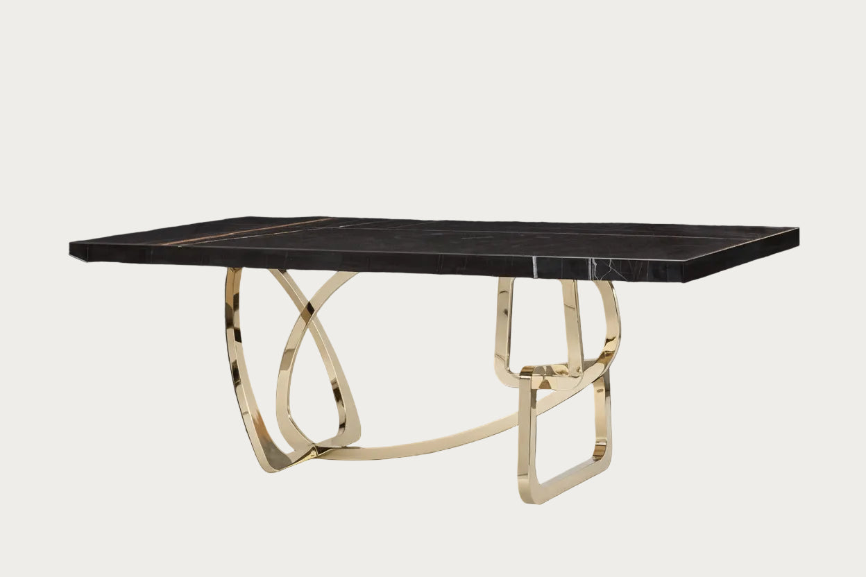 Tangle dining table with black marble top and gold metal base on a white background.