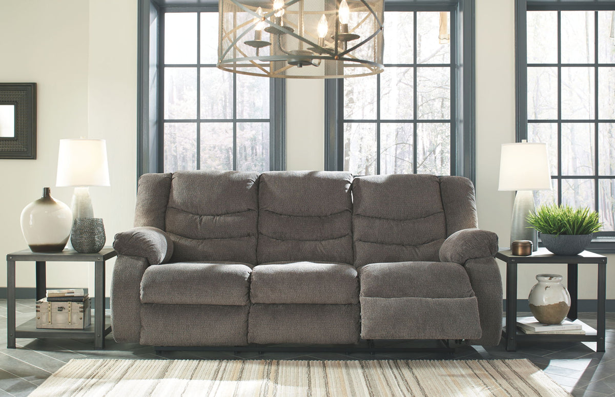 Gray sectional sofa in a living room with large windows and decorative items.
