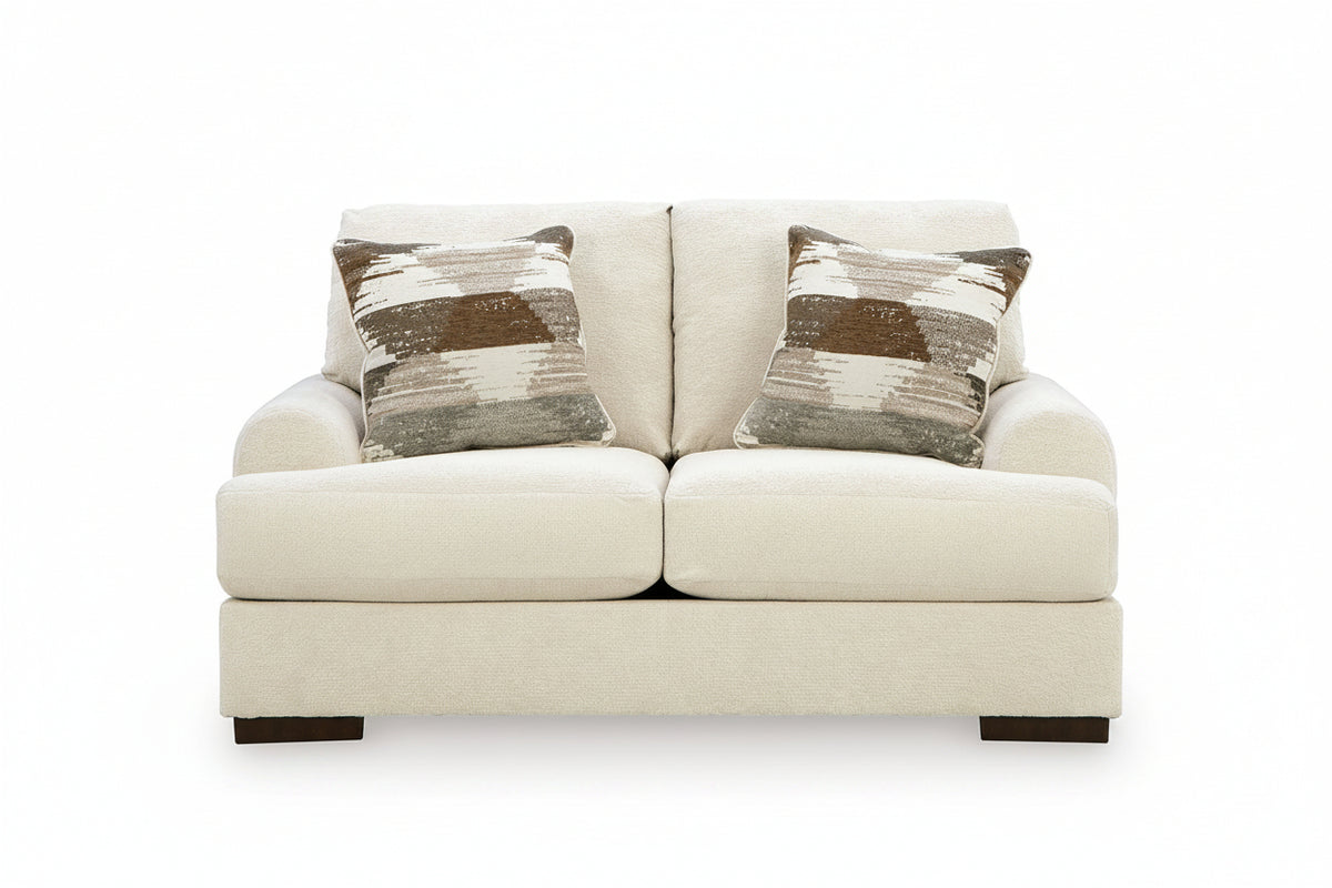 White sofa with two patterned cushions on a white background