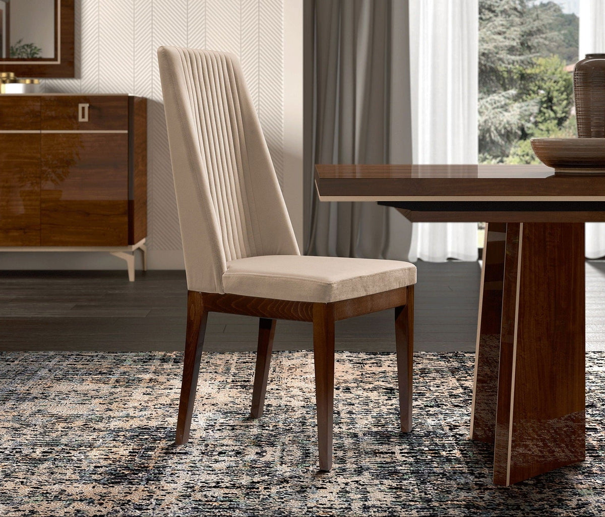 A modern dining chair with a cream upholstered seat and pleated backrest, paired with dark wood legs, shown in a contemporary dining room setting next to a matching wooden table.