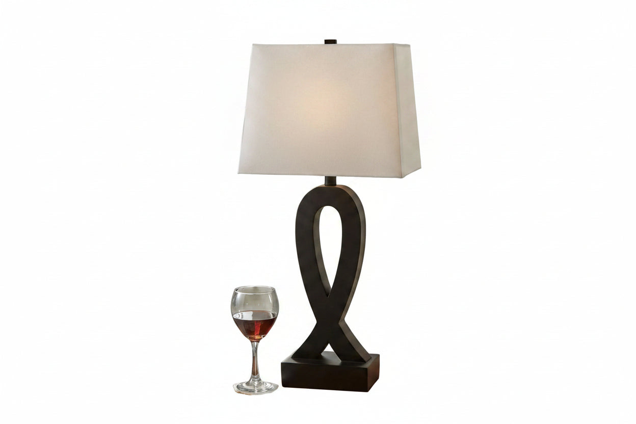 Table lamp with a decorative base on a wooden table in a living room setting.
