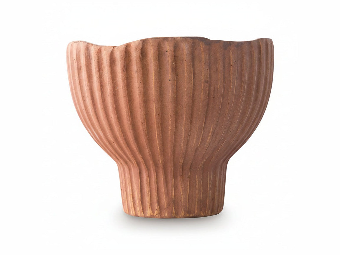 Terracotta-colored ceramic vase with ribbed texture on a white background