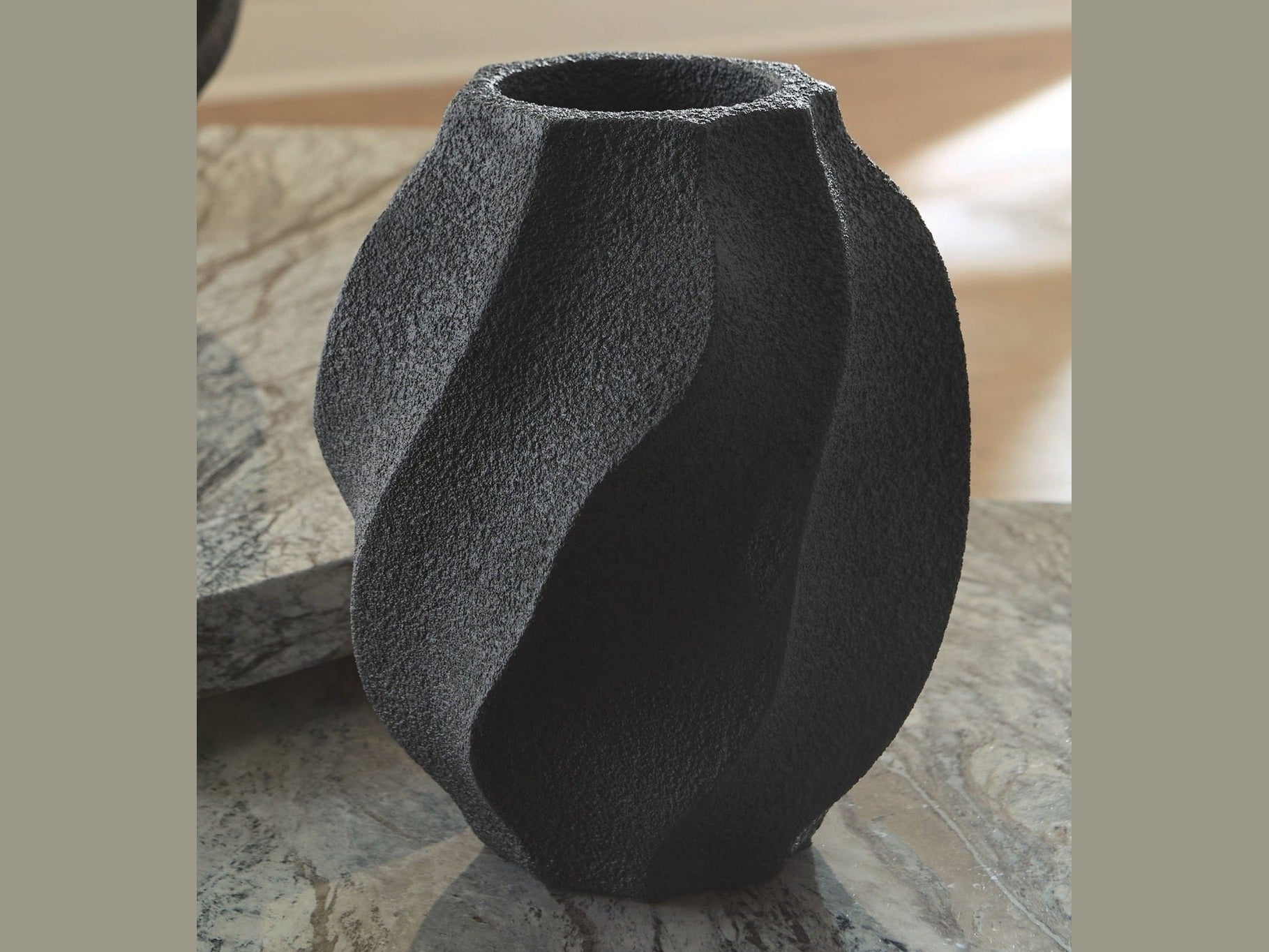 Black textured vase on a stone surface