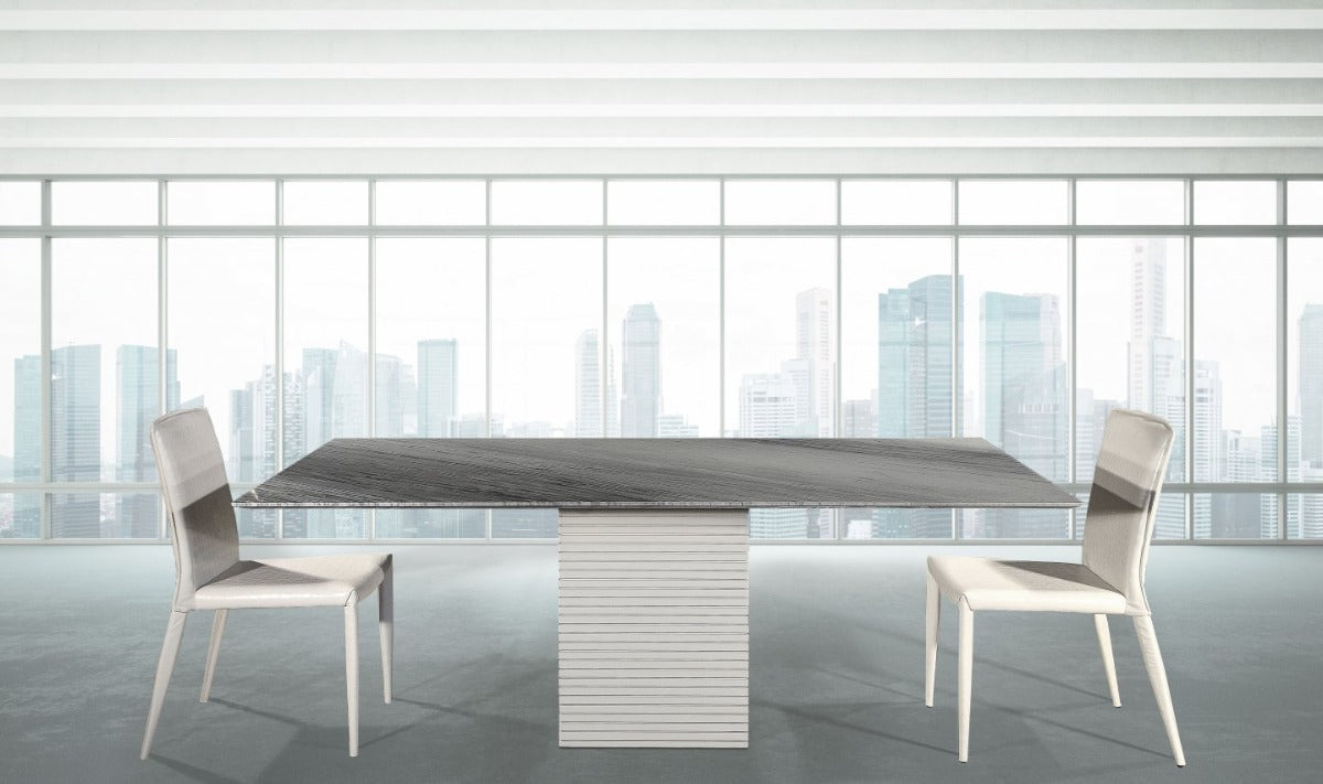 Modern dining table with chairs in a room with large windows showing a cityscape.