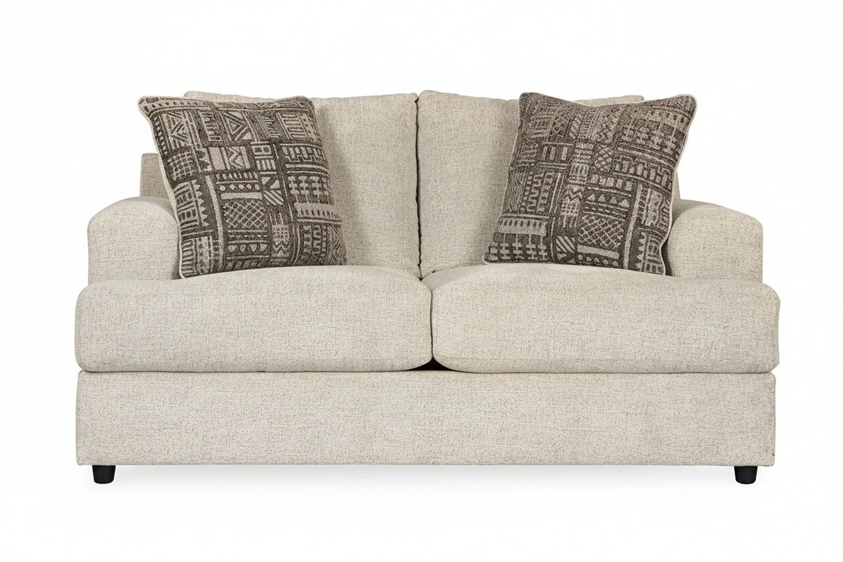 Beige sofa with patterned brown cushions on a white background