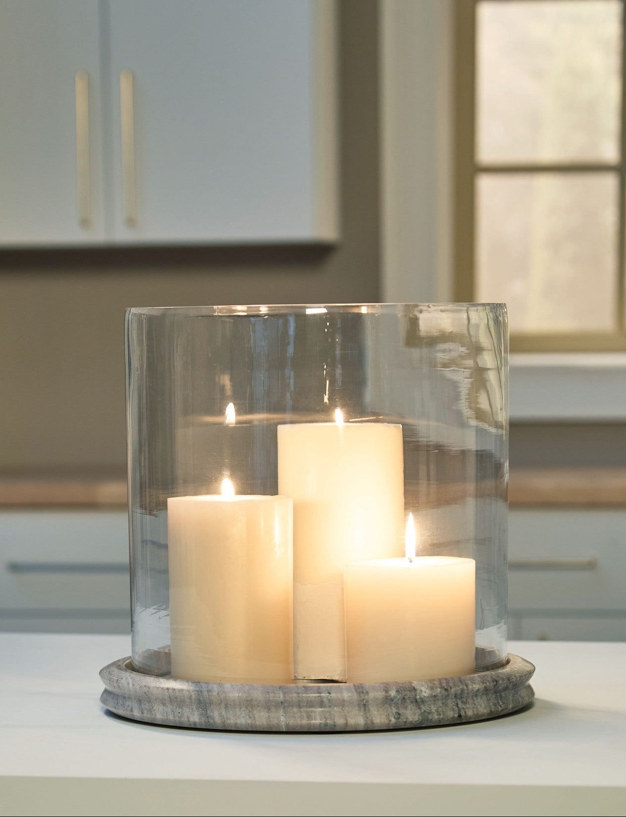 Candle holder with three candles on a surface in a kitchen setting