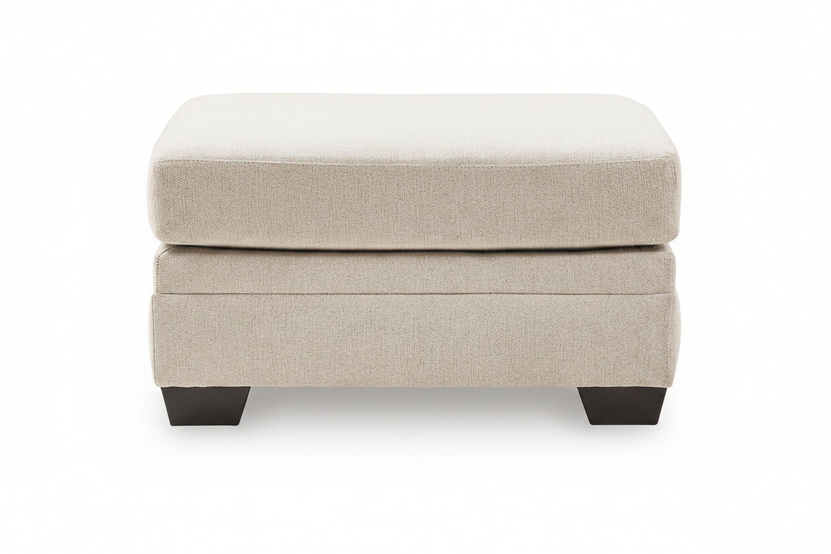 A two-tiered upholstered ottoman in a textured beige fabric, featuring dark charcoal block feet, shown against a plain white background.