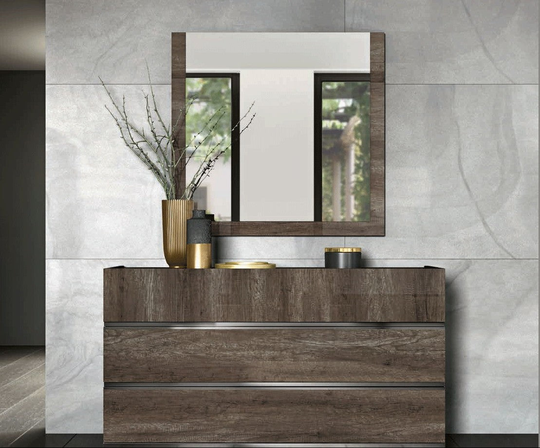 A modern bathroom vanity set featuring a dark brown wood three-drawer cabinet with a matching rectangular mirror above it, styled against a light gray marble-look tiled wall.