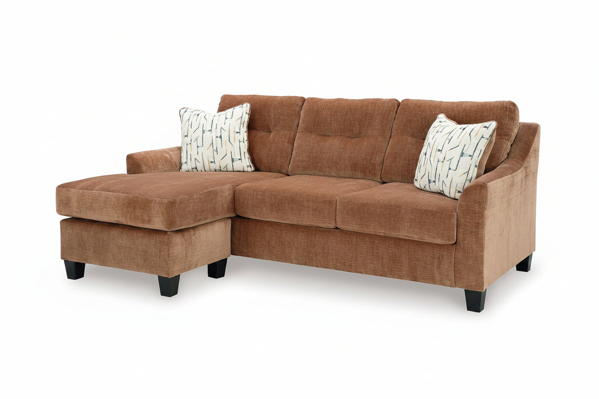 Brown sectional sofa with patterned cushions on a white background