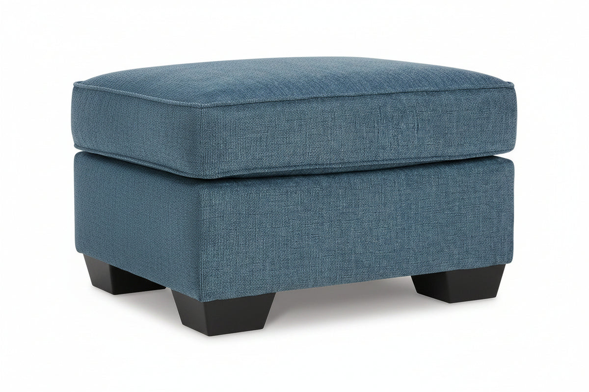 Blue upholstered ottoman on a white background