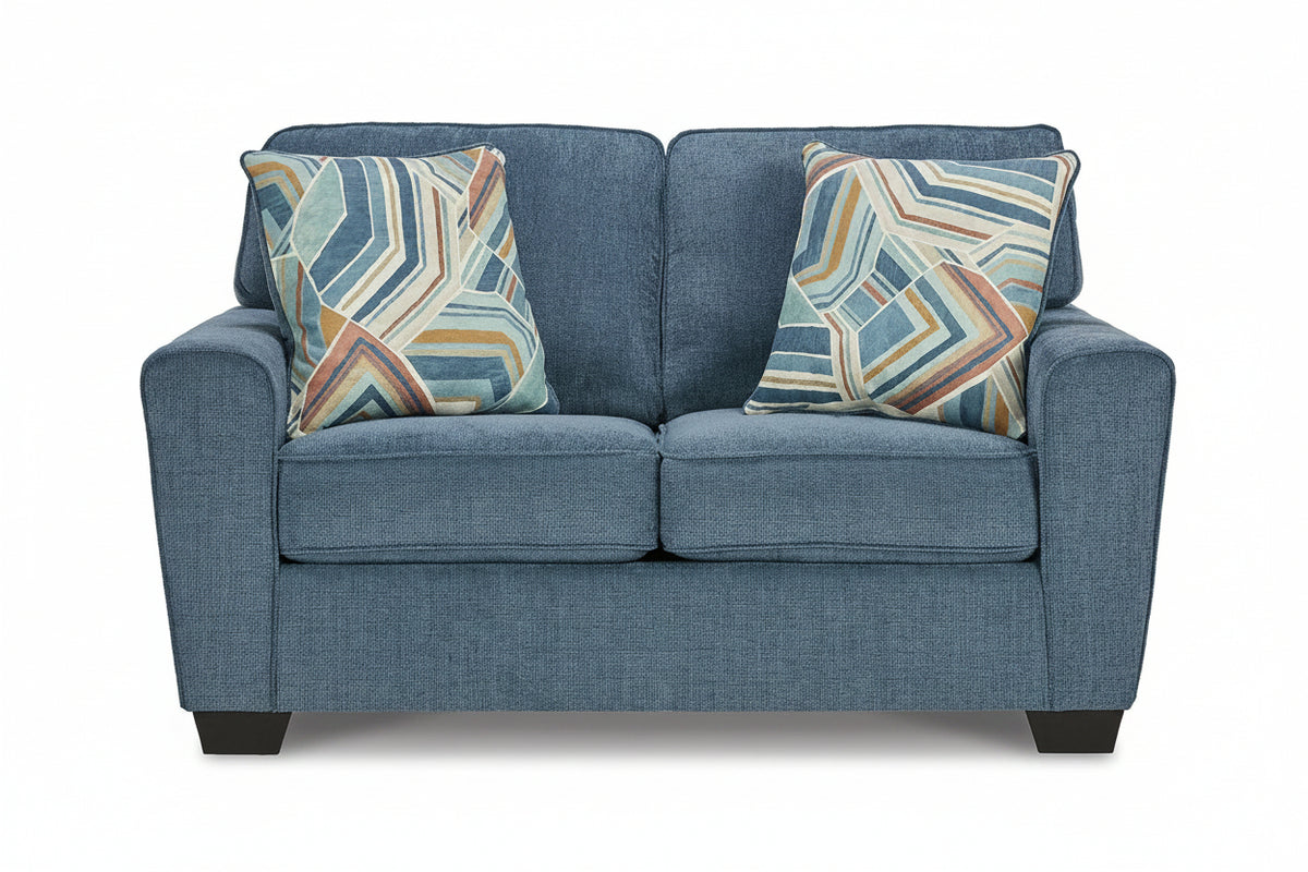 Blue sofa with patterned cushions on a white background