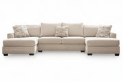 A light beige fabric sectional sofa with a left-facing chaise lounge, four matching throw pillows, and two patterned accent pillows, shown against a plain white background.