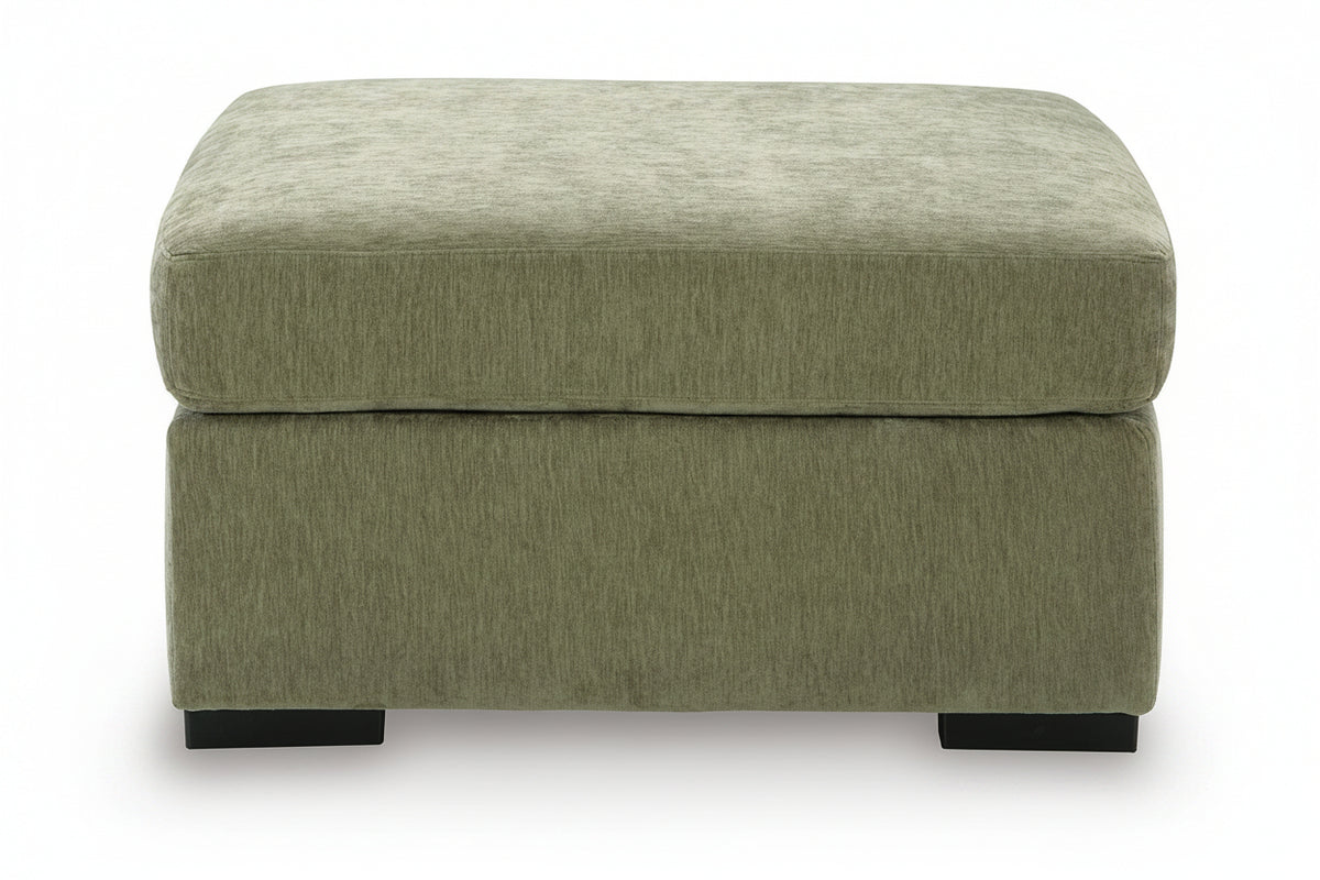 An upholstered ottoman with a square top and a thick base, upholstered in a textured sage green fabric, shown against a plain white background.