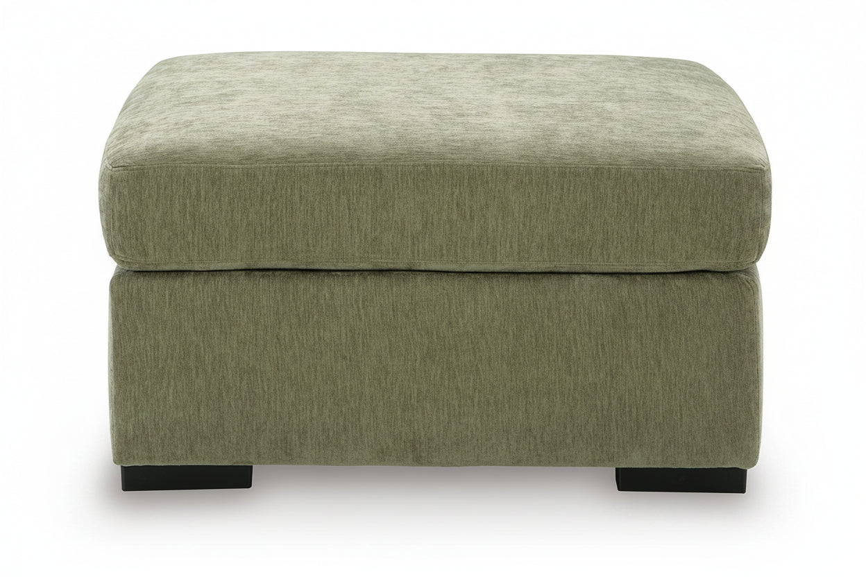 An upholstered ottoman with a square top and a thick base, upholstered in a textured sage green fabric, shown against a plain white background.