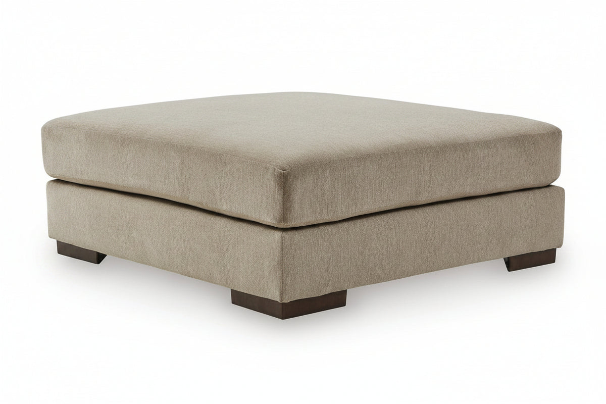 A square upholstered ottoman with a thick cushioned top and dark wooden feet, shown on a plain white background.