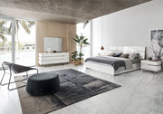 Artemide modern bedroom with white furniture, a gray rug, and large windows.