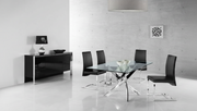 Modern dining room with glass table and black chairs in a minimalistic setting.