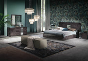 Heritage modern bedroom with dark wood furniture, floral wallpaper, and decorative lighting.