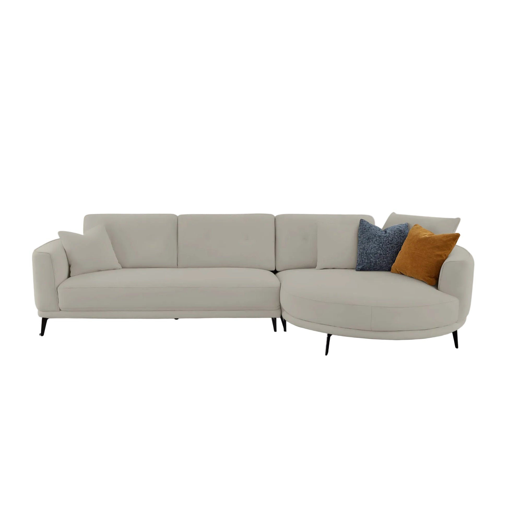 A modern curved sectional sofa upholstered in light warm gray fabric, styled with two accent pillows in blue and mustard yellow, set against a solid light gray background.